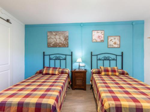 2 camas en una habitación con paredes azules en Cortijo la erilla en Dúrcal