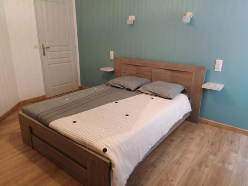 a large bed in a bedroom with a wooden floor at Appartement moderne dans village de charme in Salviac