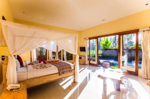 a bedroom with a bed with a canopy at Asri Sari Villa Ubud in Ubud