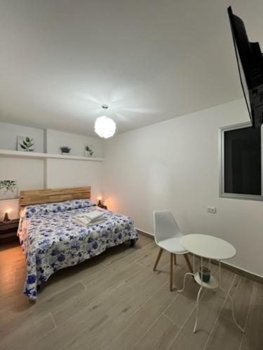 a bedroom with a bed and a table and a tv at Garden Rooms in Reggio Calabria