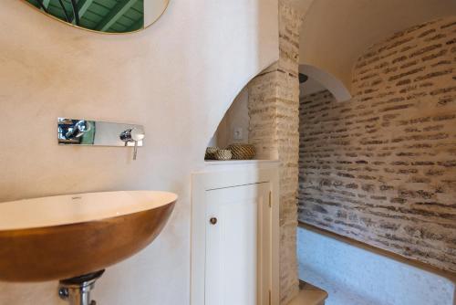 a bathroom with a wooden sink and a brick wall at Magno Apartments Rocío in Seville