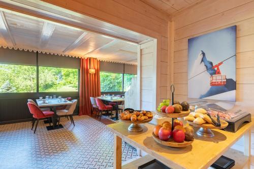 a dining room with a table with fruit on it at Hotel Le Bois Joli in Bernex