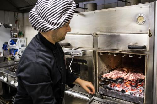 un hombre está poniendo carne en un horno en B&B Massari, en Preturo