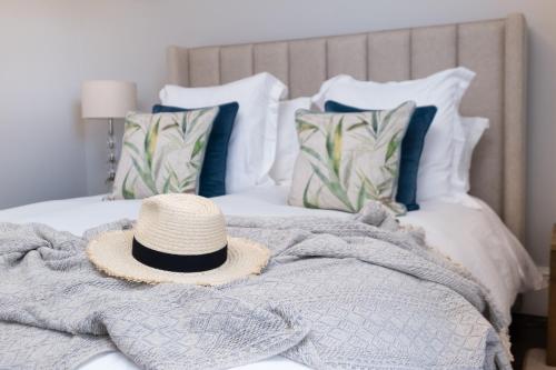 a straw hat sitting on top of a bed at The Garden Cottage of Warren Lodge boutique cottages in Dromod