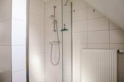 a shower with a shower head in a bathroom at Appartement op de 1e verdieping. in Wemeldinge