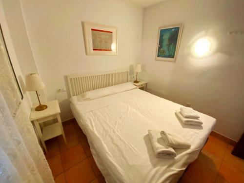 ネルハにあるApartment over torrecilla beach promenadeの小さなベッドルーム(白いベッド、タオル付)