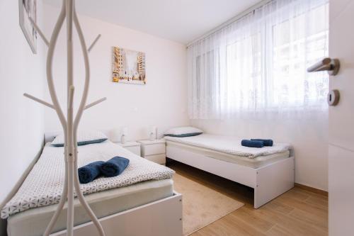 2 camas en una habitación blanca con ventana en Adriatico, en Split