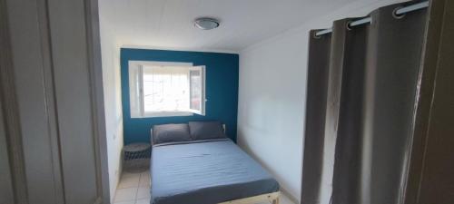 um pequeno quarto com uma cama e uma janela em Appartement 45 m² proche du centre ville em Lunel