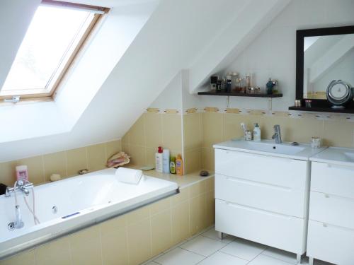 Challes的住宿－Chambres des 24h00 du Mans，浴室配有盥洗盆和浴缸。