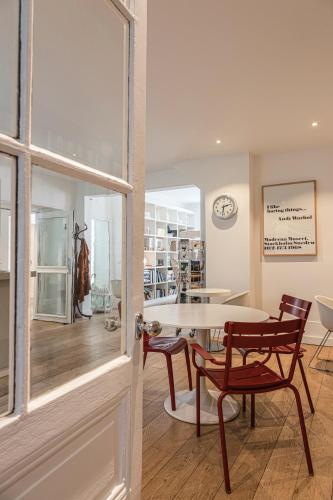 uma sala de jantar com mesa e cadeiras e um relógio em Hôtel Arvor Saint Georges em Paris