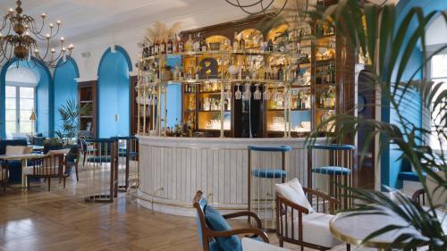 a bar in a restaurant with blue walls and chairs at Villa Agrippina Gran Meliá – The Leading Hotels of the World in Rome