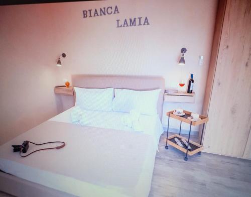 una camera da letto con un letto bianco con un cartello sul muro di BIANCA LAMIA Ostuni a Ostuni