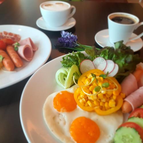 a plate of food with eggs and vegetables on a table at Admiral Premier Bangkok in Bangkok