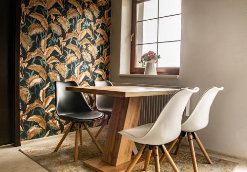 a dining room with a table and four chairs at Rezidence Rokytnice in Rokytnice nad Jizerou