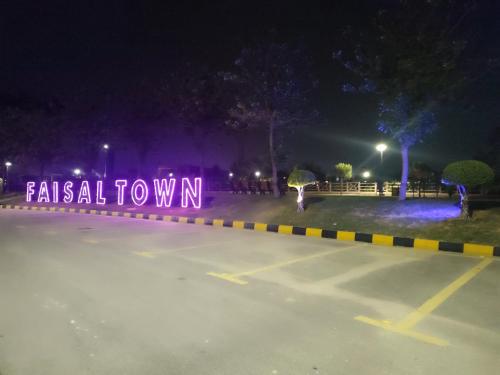 a neonatal town sign is lit up at night at Lavish Inn Islamabad in Islamabad