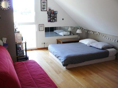 1 dormitorio con cama y sofá en Chambres des 24h00 du Mans, en Challes