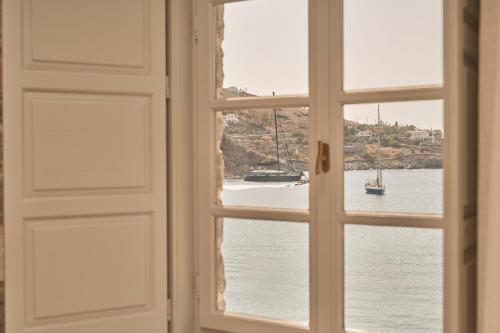 an open window with a view of a body of water at Mandraki Beach Resort in Mandraki