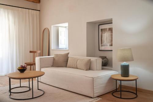a living room with a white couch and two tables at Mandraki Beach Resort in Mandraki