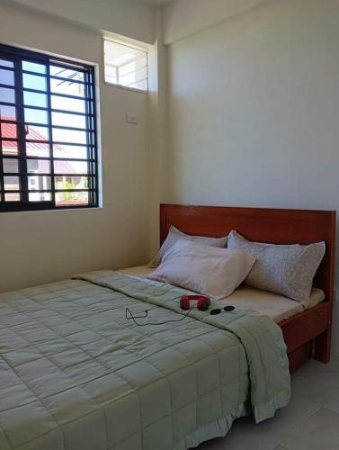 a bedroom with a large bed with glasses on it at Reinhardshausen Suites and Residences - Cozy Air-conditioned Units in Tuguegarao City
