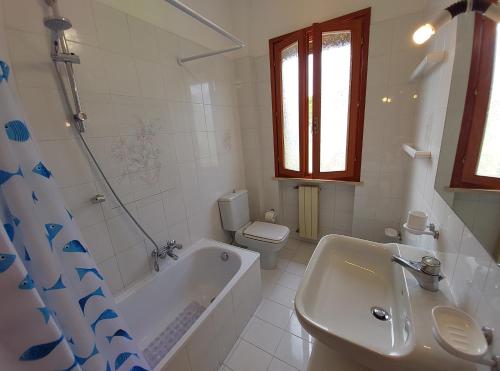 y baño con bañera, aseo y lavamanos. en Appartamento Castiglioncello 600 mt dal mare, en Castiglioncello