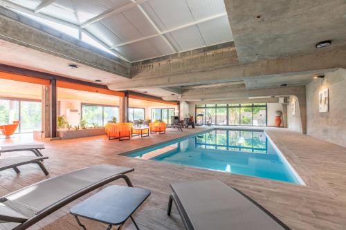 uma piscina interior numa casa com sala de estar em Château de Charmeil- Vichy chambres d'hôtes em Charmeil