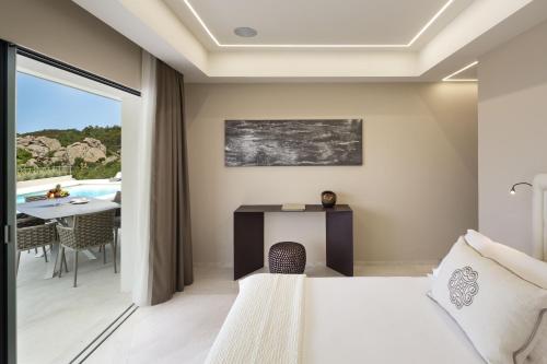 a bedroom with a bed and a dining room with a table at Hotel Li Finistreddi in Cannigione