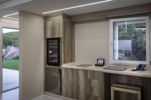a room with a counter with a window and a phone at Hotel Li Finistreddi in Cannigione
