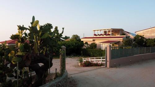 une clôture avec un cactus devant une maison dans l'établissement Michelino House, à Parghelia