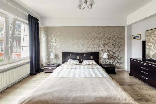 - une chambre avec un grand lit et une télévision dans l'établissement Shum Jeziora Apartament nr 7, à Giżycko