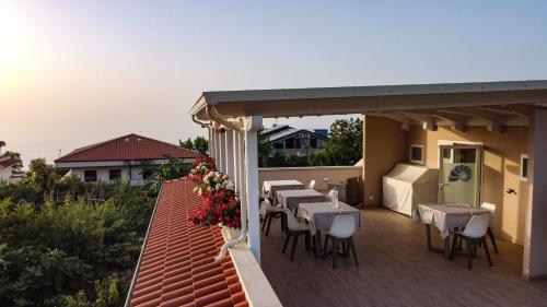 a patio with tables and chairs on a roof at Michelino House in Parghelia