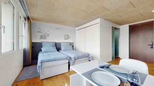 a room with two beds and a table in it at Evi's Home Hotel & Apartments in Bern