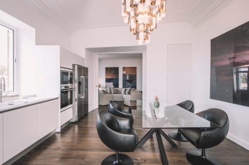 a dining room with a table and black chairs at QUINTA TORRINHA PANORAMA Apartment in Funchal