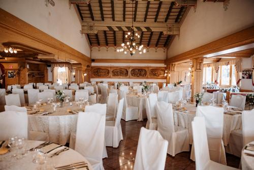 un salón de banquetes con mesas blancas y sillas blancas en Hotel Da Franco e Adriana en Pieve Di Ledro