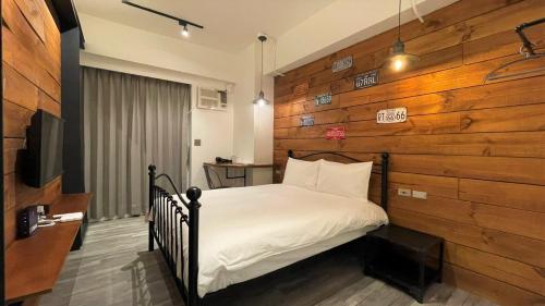 um quarto com uma cama e uma parede de madeira em Sky Tree B&B em Taichung