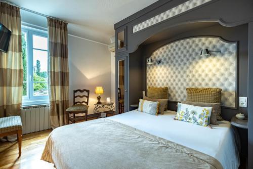 a bedroom with a large bed with a large headboard at Hostellerie Bourguignonne in Verdun-sur-le-Doubs