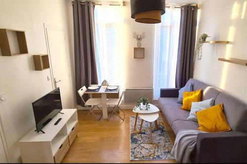 ein Wohnzimmer mit einem Sofa und einem TV in der Unterkunft Cosy Studio au coeur de Rouen in Rouen