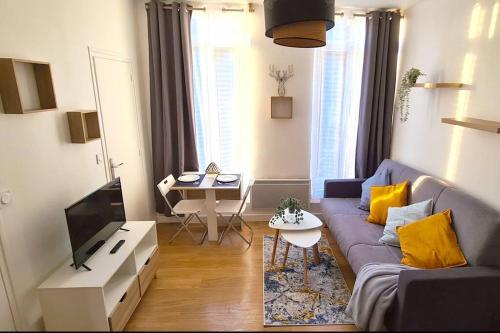 un salon avec un canapé et une télévision dans l'établissement Cosy Studio au coeur de Rouen, à Rouen