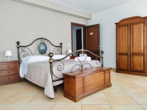 1 dormitorio con cama y tocador de madera en Città Dei Templi GuestHouse, en Agrigento
