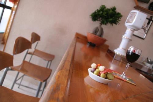 a bowl of fruit on a wooden table with a glass of wine at Hotel Levante in Guardamar del Segura