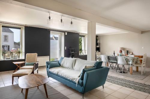 un salon avec un canapé et une salle à manger dans l'établissement Charmante maison proche de l'océan pour 8 personnes, à Sarzeau
