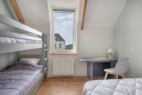 a bedroom with a bed and a desk and a window at Charmante maison proche de l'océan pour 8 personnes in Penvins
