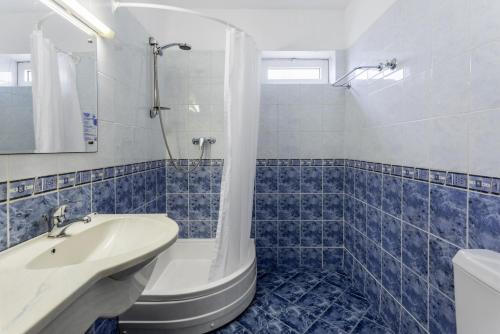 Hotel Sirena في ساتورن: حمام باللون الأزرق والأبيض مع حوض استحمام