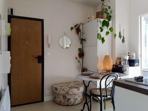 - une cuisine avec une table, des chaises et une porte dans l'établissement PARIS AUTHENTIC HOUSE Small, bright and calm studio, à Paris