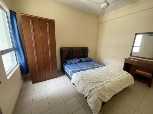 a bedroom with a bed and a wooden cabinet at Fullhouse Marina View Villas Apartment in Port Dickson