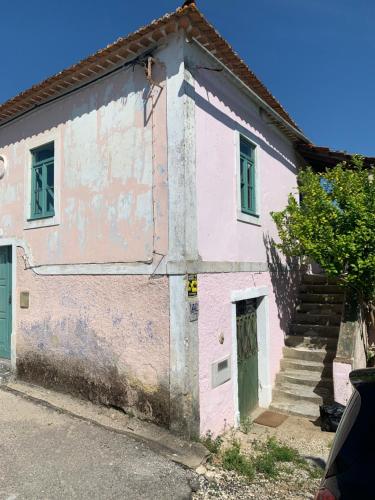 a pink house with a staircase in front of it at Anexo Casa São Miguel the beauty of imperfection in Santarém