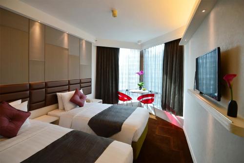 a hotel room with two beds and a television at Stanford Hotel Hong Kong in Hong Kong