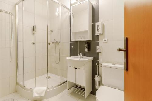 a bathroom with a shower and a toilet and a sink at Hotel Termál in Vyhne
