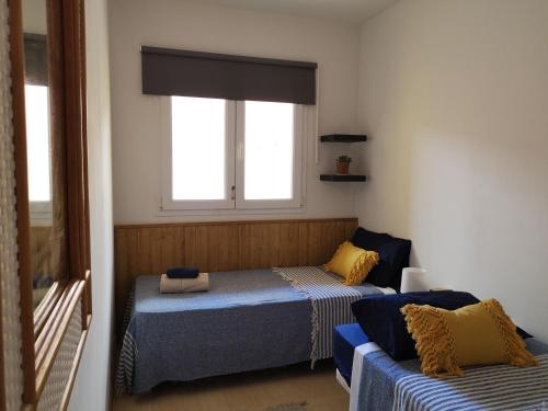 sypialnia z dwoma łóżkami i oknem w obiekcie Casa Natal. Tú rincón acogedor en El Cotillo. w mieście Cotillo