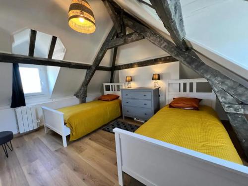 2 bedden in een zolderslaapkamer met houten vloeren bij Homefleur - Maison 130m2 - 8 à 10 pers - Jardin in Honfleur