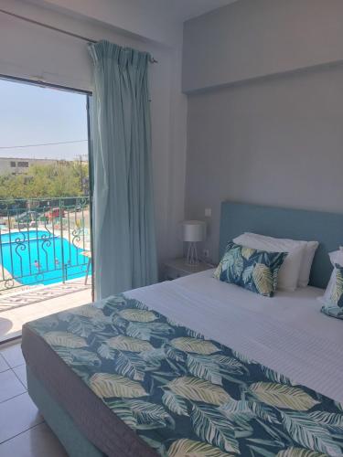 a bedroom with a bed with a view of a pool at Maria Studios in Paleokastritsa
